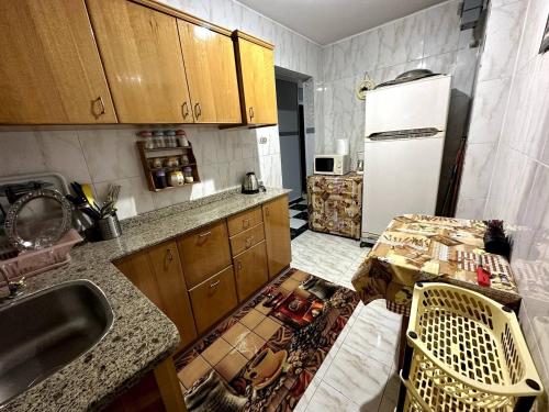 een keuken met een wastafel en een witte koelkast bij Appartement à Miami - Vu sur mer in Alexandrië