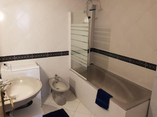 une salle de bain blanche avec un lavabo et des toilettes dans l'établissement PALMA Piscine chauffée Grand jardin avec piscine à 1 km de la mer, à Solaro