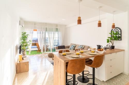 a kitchen and living room with a wooden table and chairs at Almare Suites Burbujas I - Vistas al mar, golf, junto a la playa in Almería