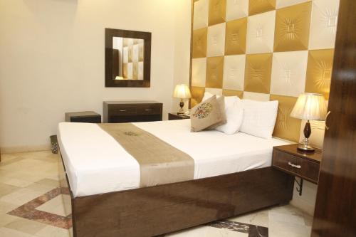 a bedroom with a large bed and a mirror at Park View Hotel Gulberg in Lahore
