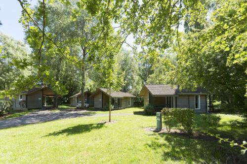 a group of houses in a yard with trees at Camping Du Port De Plaisance in Péronne