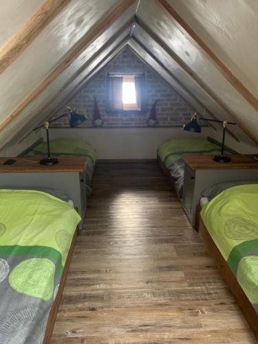 a room with three beds in a attic at Hiša Pod gorami II****-house with wellness in Kranjska Gora
