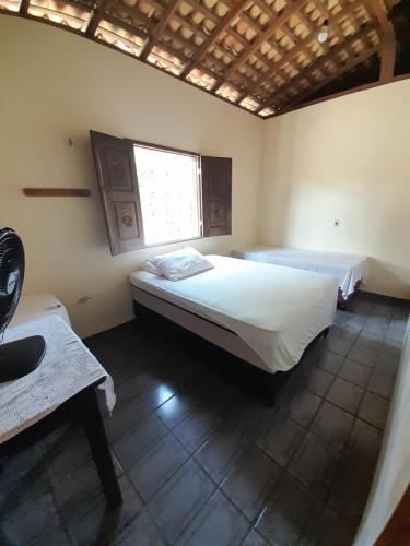 a bedroom with two beds and a window at Pousada Marlene in Barreirinhas