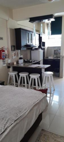 a kitchen with a bed and stools in a room at Durban Shores Holiday Apartments in Durban