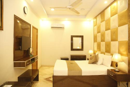 a hotel room with a bed and a television at Park View Hotel Gulberg in Lahore