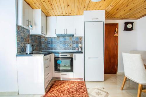 a kitchen with white appliances and a wooden ceiling at Maria House in Karpathos Town