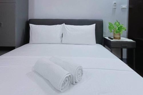 Una cama blanca con toallas encima. en 5 - Cabanatuan City's Best Bed and Breakfast Place en Cabanatuan