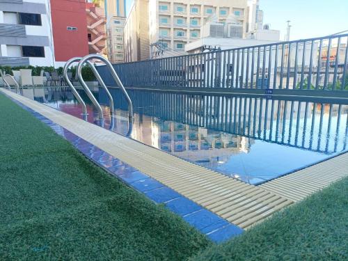 a swimming pool with blue tiles and a metal fence at Star Hotel Chiang Mai - SHA Extra Pus in Chiang Mai