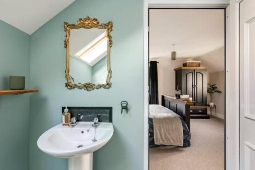 a bathroom with a sink and a mirror on the wall at Willow Lodge, Wolfscastle in Haverfordwest