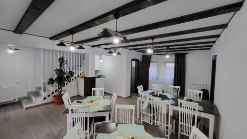 Racoşu de Jos的住宿－PENSIUNEA CASTELANA，用餐室配有白色的桌子和白色的椅子
