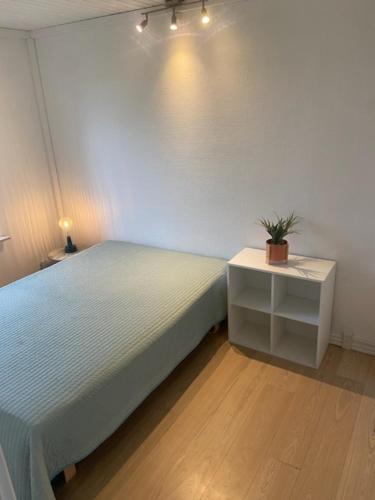 Un dormitorio con una cama y una mesa con una planta. en VV Apartments 50,1, en Ringsted