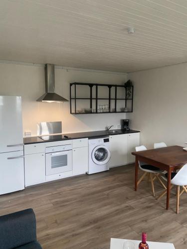 a kitchen with white appliances and a table with chairs at VV Apartments 50,1 in Ringsted