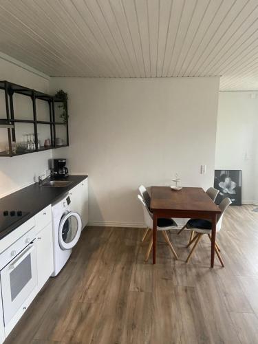 een keuken met een tafel en een wasmachine bij VV Apartments 50,1 in Ringsted