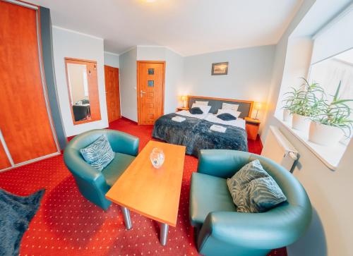 a bedroom with a bed and a table and chairs at Willa Szafir in Kołobrzeg