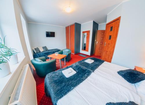 a hotel room with a large bed and a living room at Willa Szafir in Kołobrzeg
