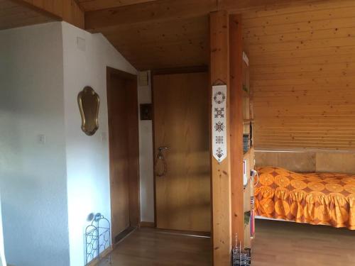 a bedroom with a bed and a wooden door at 2-room-apartment with shared garden place and view on nature reserve in Brügg