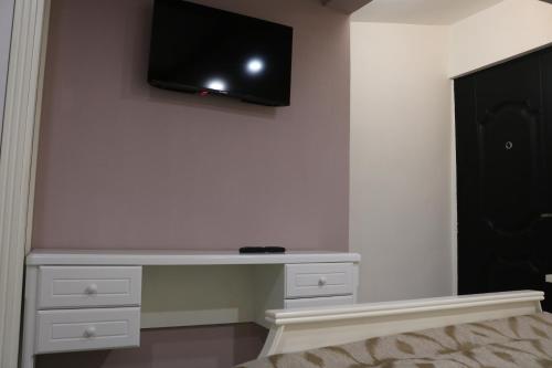 a room with a tv on a wall with a shelf at Kai Hotel Bar in Tbilisi City