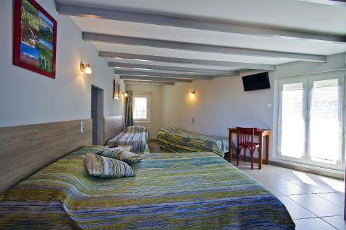 a hotel room with two beds and a table at Auberge du Bon Vivant in Argelès-sur-Mer