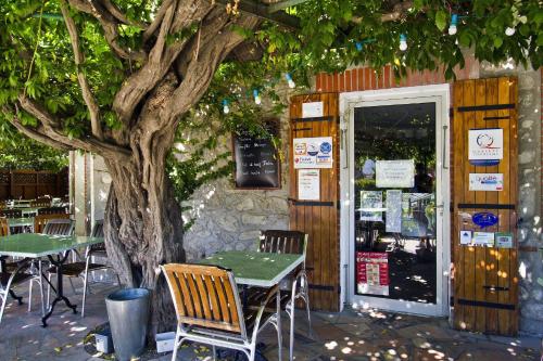 a restaurant with tables and chairs and a tree at Auberge du Bon Vivant in Argelès-sur-Mer