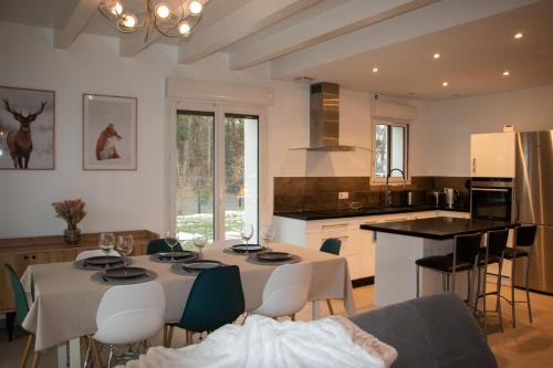 eine Küche mit einem Tisch und Stühlen sowie ein Esszimmer in der Unterkunft A l’orée du Vuache 