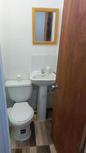 a bathroom with a toilet and a sink at Departamentos villamar guanaquero in Coquimbo