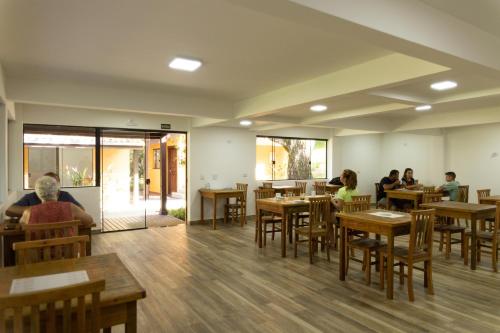 personas sentadas en un restaurante con mesas y sillas en Pousada Villa Encantada Ilha do Mel en Ilha do Mel