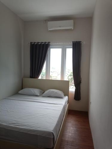 a bedroom with a bed and a window at 158 Guest House Syariah RedPartner in Bandung