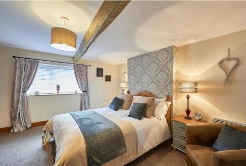 Cosy Cumbrian cottage for your country escape في Brough: غرفة نوم بسرير كبير وأريكة