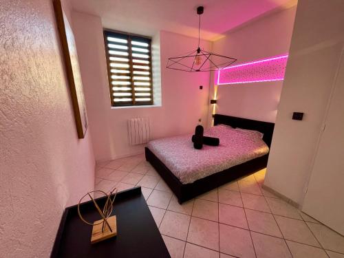 een slaapkamer met 2 bedden en een paars licht bij Le Gold&Black proximité de Metz 
