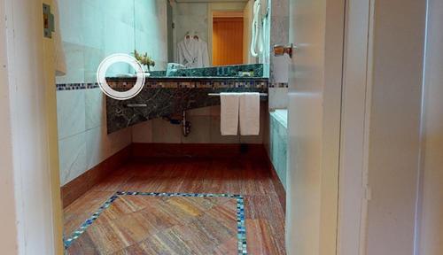 a bathroom with a sink and a mirror at Dan Eilat Hotel in Eilat