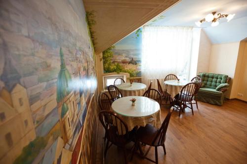 Un restaurante con mesas y sillas en una sala. en Mini-Hotel Guest House Inn Lviv, en Leópolis