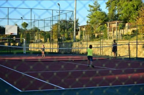 un grupo de personas jugando al tenis en una pista de tenis en Villa soso en Okurcalar