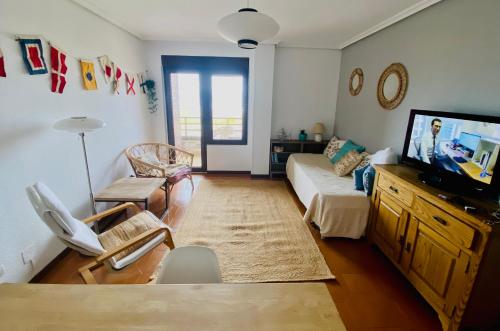 a living room with a couch and a flat screen tv at Vistas al Mar in Somo