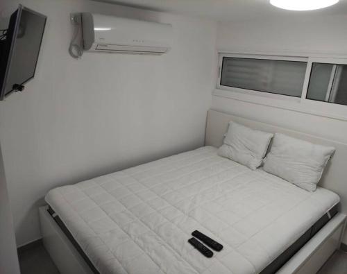 een klein bed in een kleine kamer in een trailer bij יחידת אירוח חדשה ומקסימה בכרמיאל in Karmiël