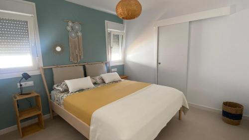 1 dormitorio con 1 cama grande y paredes azules en Casa Costa Ecologica y de Design con Piscina, Jardin y Parking, en Chiclana de la Frontera