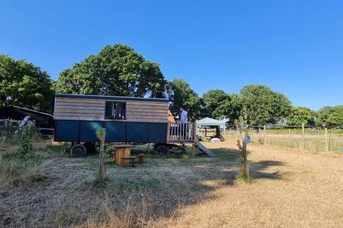 a man standing on a porch of a tiny house at Penelope in West Chiltington