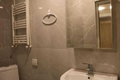 a bathroom with a sink and a mirror and a toilet at Kai Hotel Bar in Tbilisi City