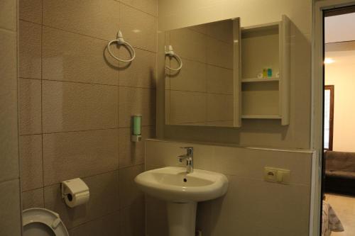 a bathroom with a sink and a mirror and a toilet at Kai Hotel Bar in Tbilisi City