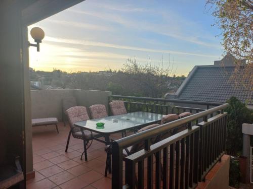 a patio with a table and chairs on a balcony at LISA VILLAGE in Bloemfontein