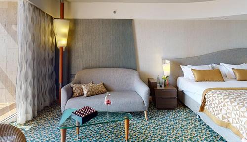 a hotel room with a bed and a couch at Dan Eilat Hotel in Eilat