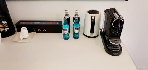 a counter with two soda bottles and a cell phone at sonniges Zimmer mit Balkon im Herzen Mannheims in Mannheim