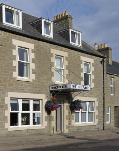 un gran edificio de ladrillo con un hotel al alcance en St Clair Hotel en Thurso