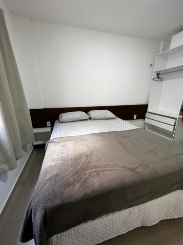 a bedroom with a large bed with white walls at Casa à 500 da Praia in Salinópolis