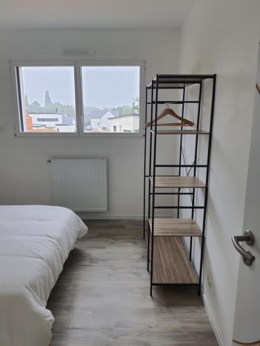 a room with a book shelf next to a bed at Maison neuve cosy à 20 min des plages #lorient #cosy in Pont-Scorff