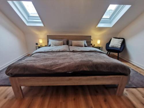 a bedroom with a large bed with two skylights at Moderne Ferienwohnung Iserlohn in Iserlohn