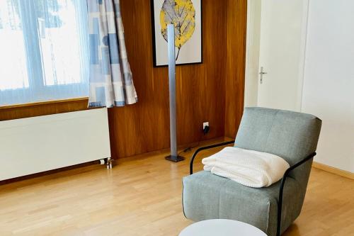 sala de estar con silla y lámpara de pie en Cozy Corner - CharmingStay en Flumserberg