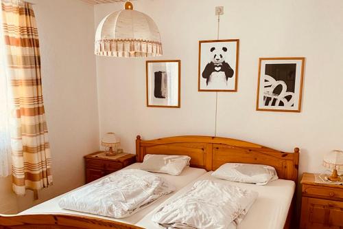 a bedroom with two beds and a panda picture on the wall at Cozy Corner - CharmingStay in Flumserberg