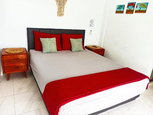 a bedroom with a large bed with red pillows at Loka Anyar Guest House in Kerobokan