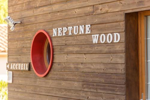 aperature wood sign on the side of a building at Chambre d’Hôtes Neptune Wood in Arzens