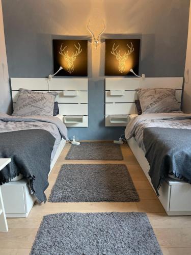 a bedroom with two beds and a rug at Appartment 53qm im Architektenhaus - 2 Schlafzimmer mit Küche und Bad, nur 2min von A8 - ruhig und modern in Irschenberg